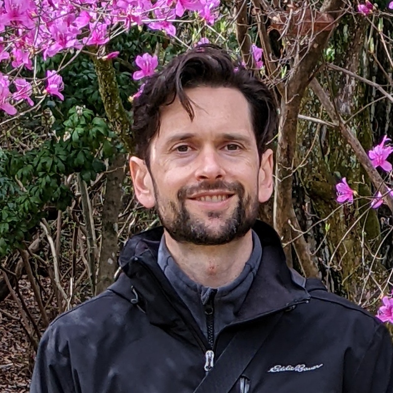 Daniel I Stein outdoors beside flowering trees